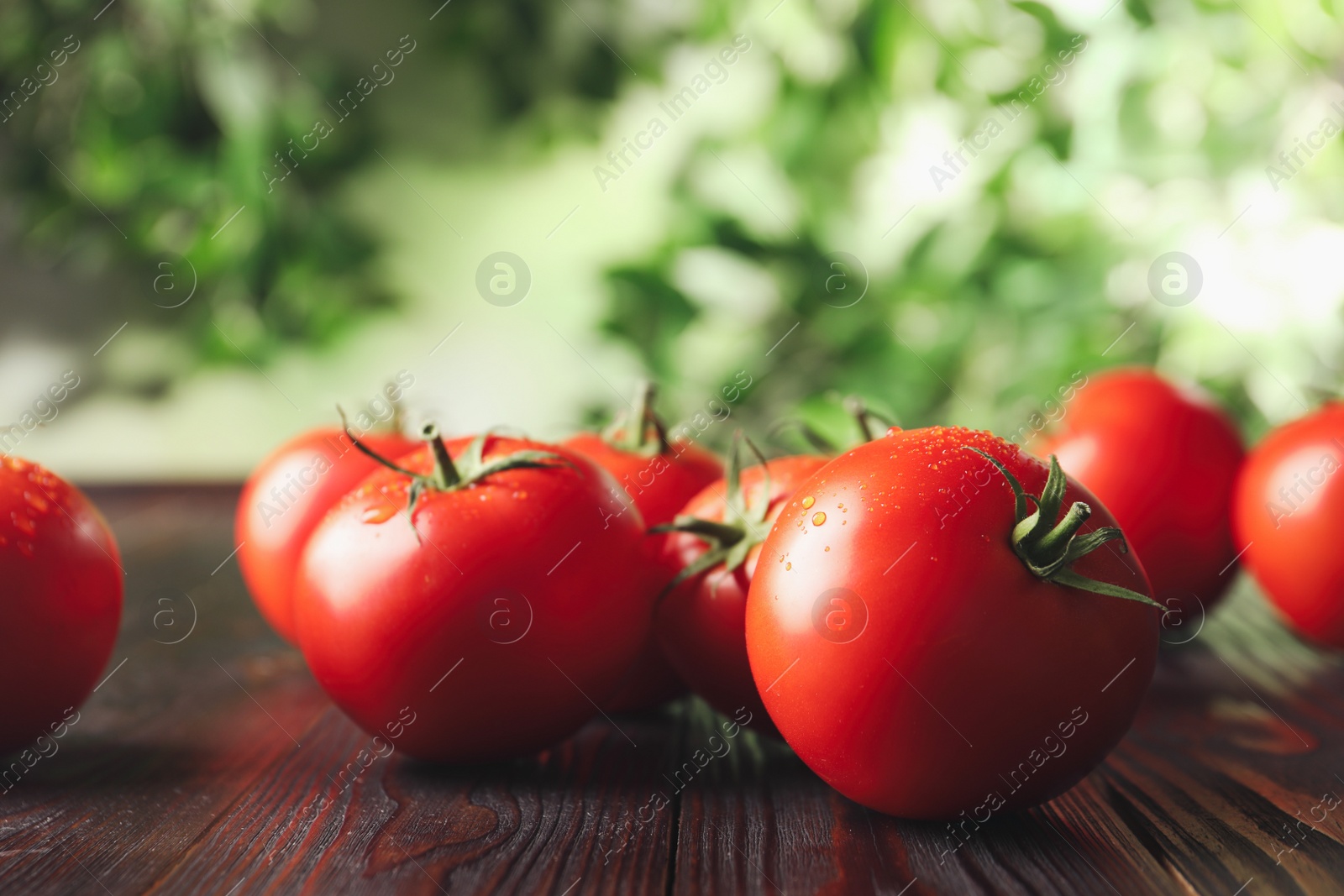 Photo of Fresh ripe red tomatoes on wooden table