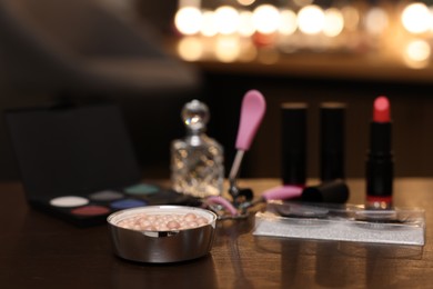 Photo of Blush pearls and other beauty products on wooden table. Makeup room