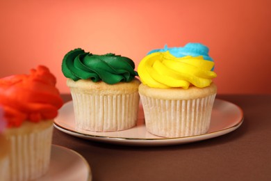 Photo of Delicious cupcakes with bright cream on color background