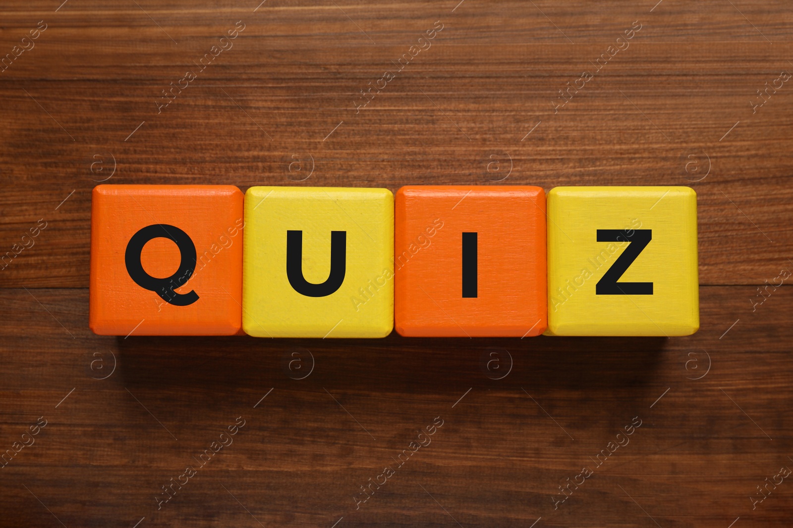 Photo of Colorful cubes with word Quiz on wooden table, flat lay