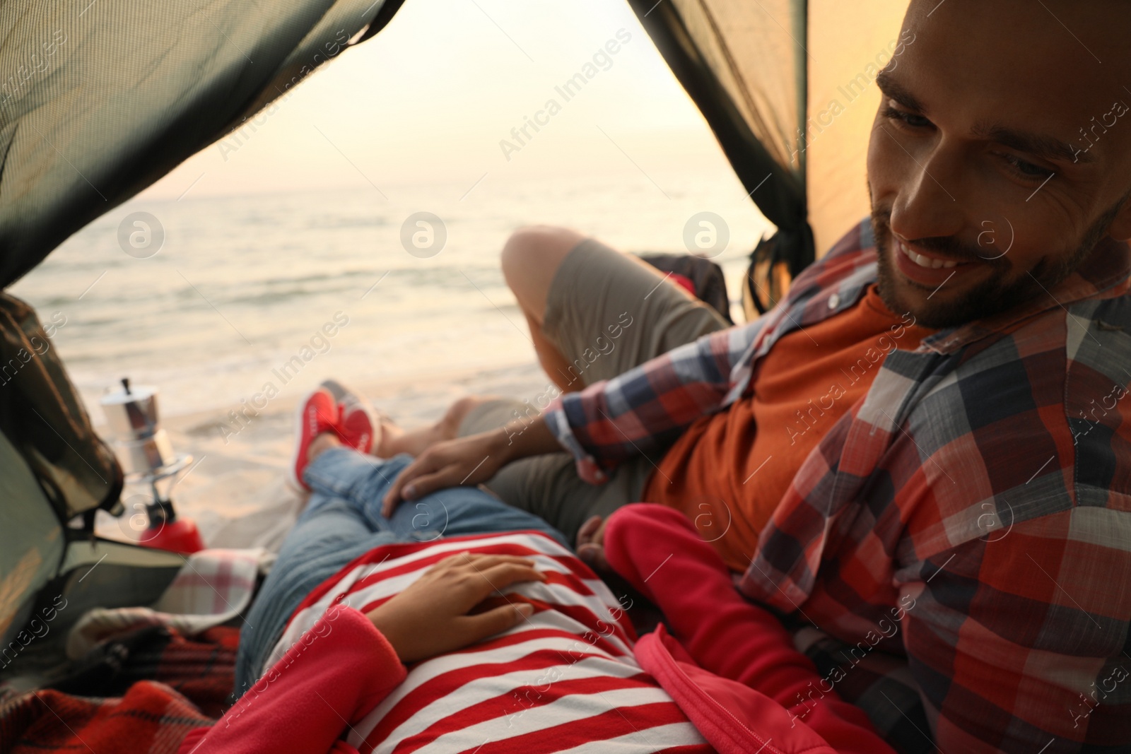 Photo of Couple resting in camping tent near sea