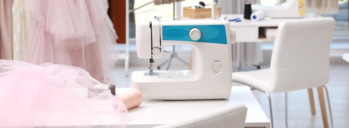 Sewing machine and equipment on table in dressmaking workshop. Banner design