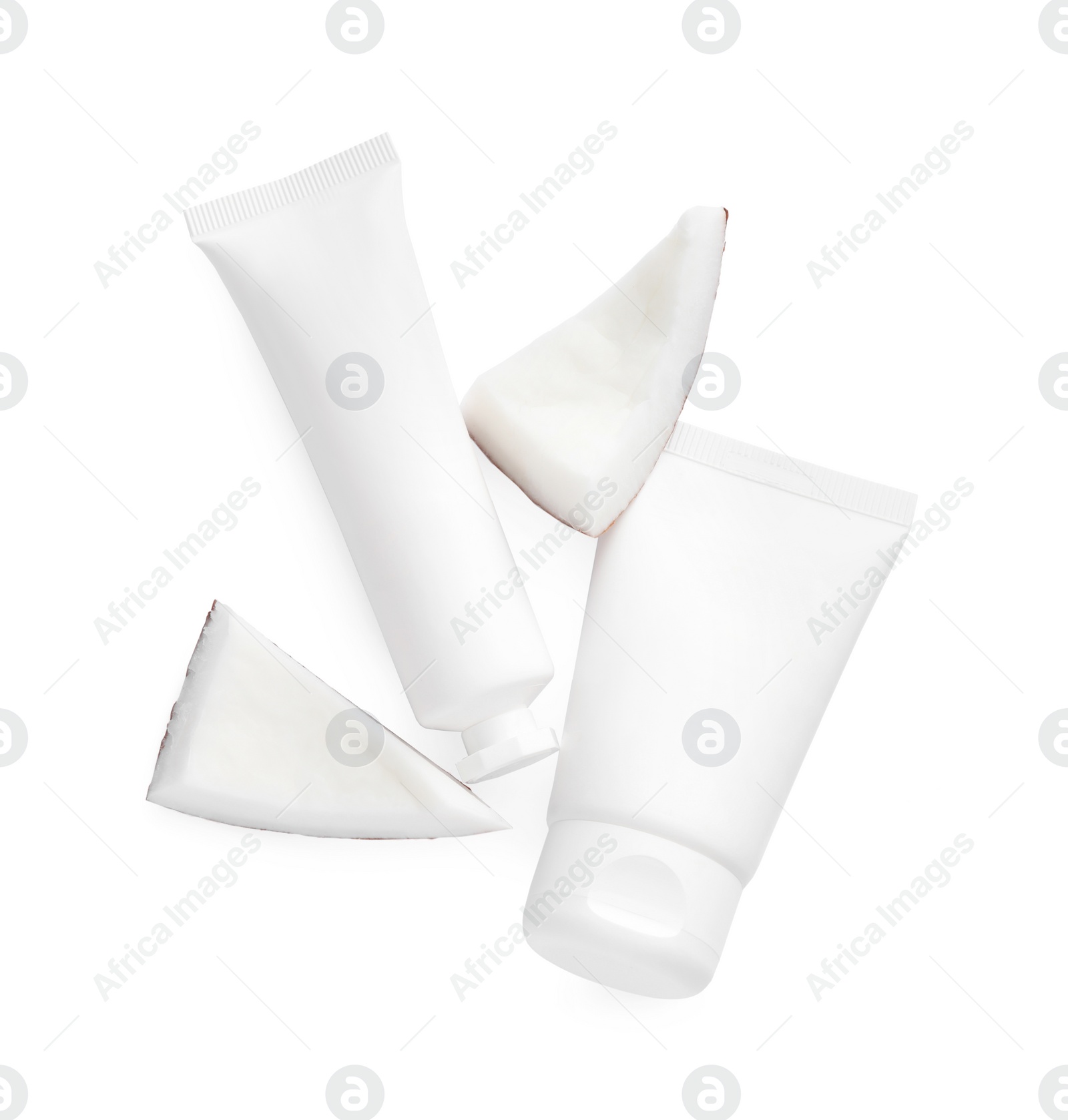 Photo of Tubes of hand cream and coconut pieces on white background, top view