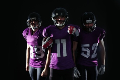 American football players in uniform on dark background