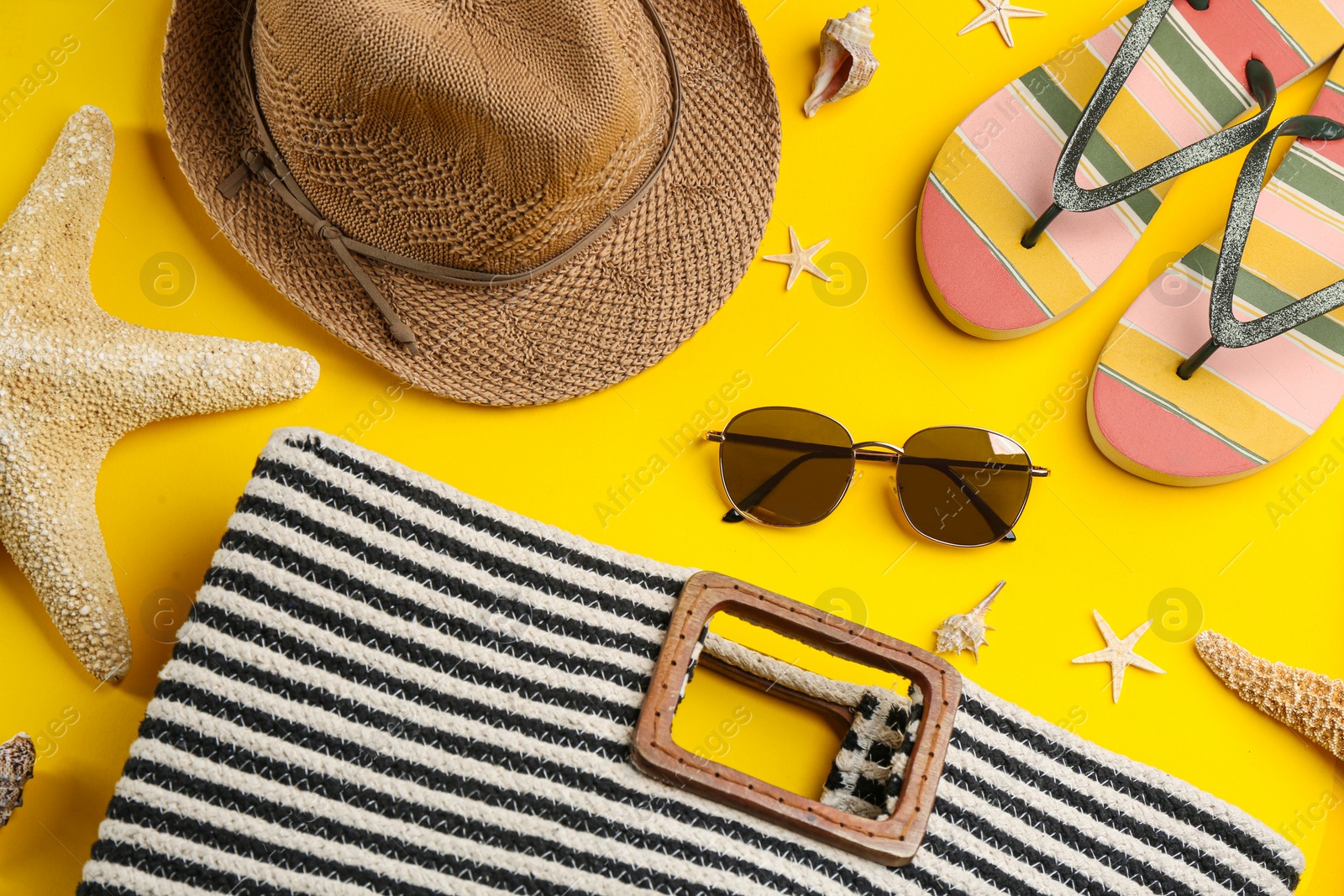 Photo of Flat lay composition with sunglasses and beach accessories on yellow background