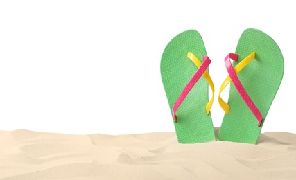 Photo of Green flip flops in sand on white background