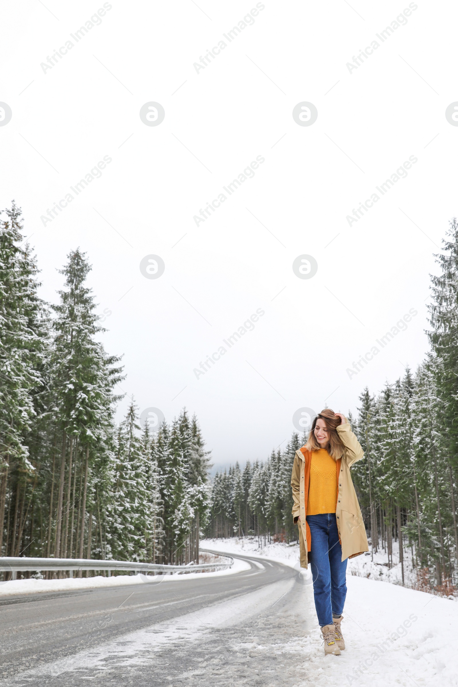 Photo of Young woman walking near snowy forest. Winter vacation