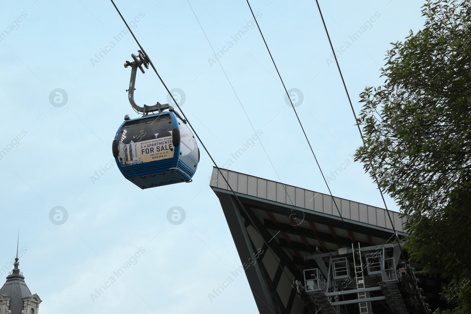 Photo of BATUMI, GEORGIA - MAY 31, 2022: Cableway with cabin against cloudy sky, low angle view