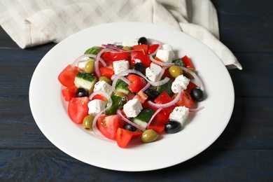 Photo of Plate with delicious fresh salad on table