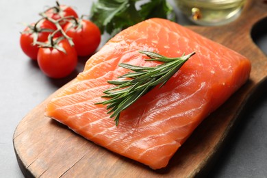 Fresh raw salmon and ingredients for marinade on grey table, closeup