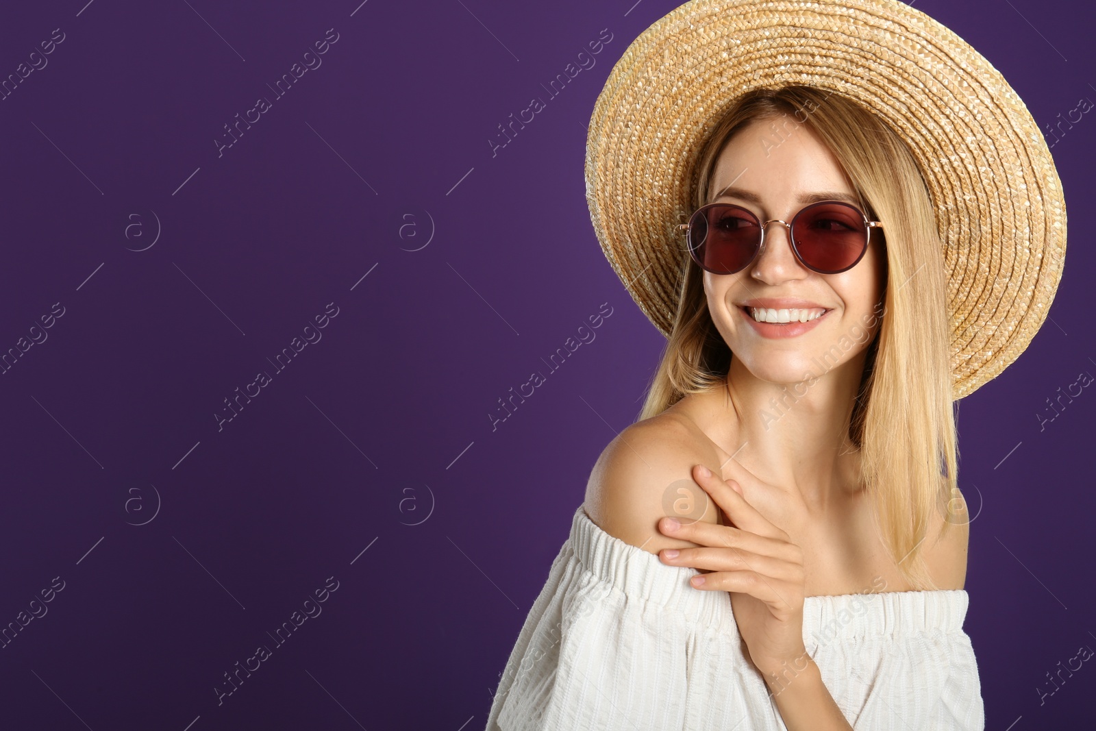 Photo of Beautiful woman in stylish sunglasses on purple background. Space for text