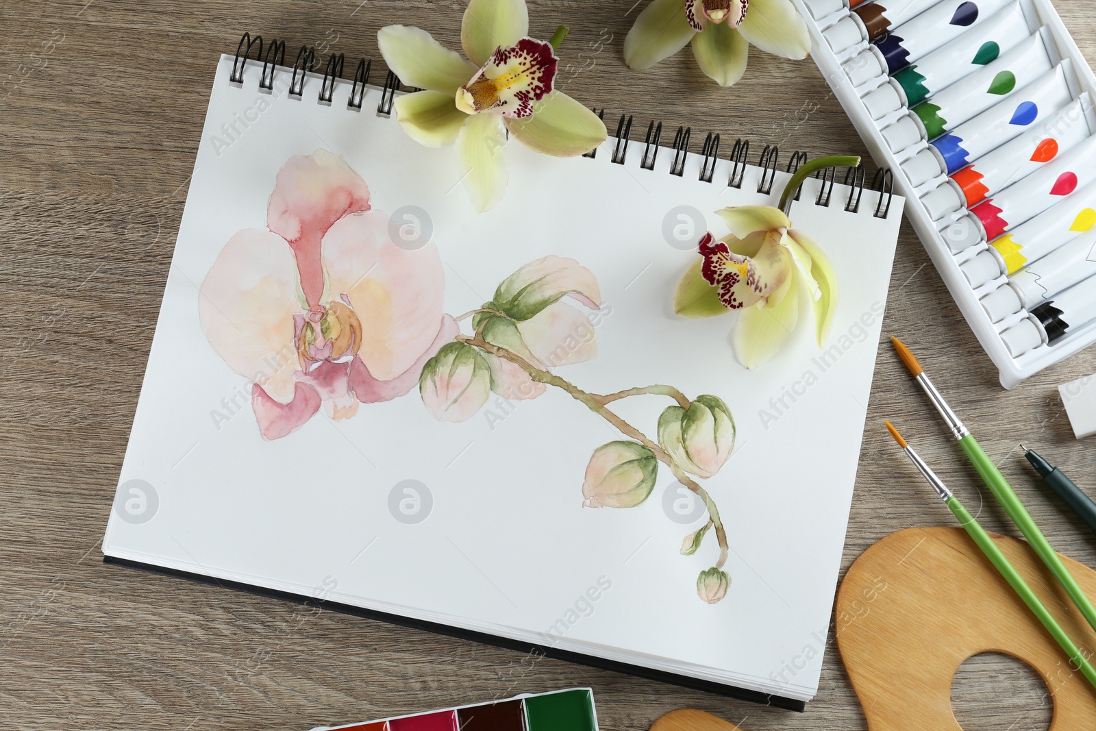 Photo of Flat lay composition with beautiful drawing of orchid
flowers on wooden table