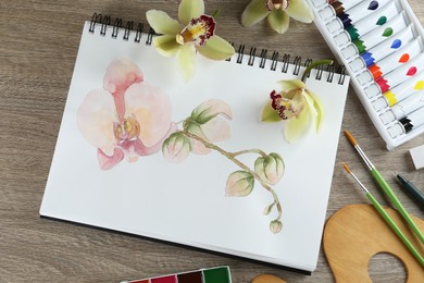Photo of Flat lay composition with beautiful drawing of orchid
flowers on wooden table