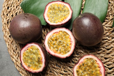 Passion fruits (maracuyas) and green leaf on wicker mat, flat lay