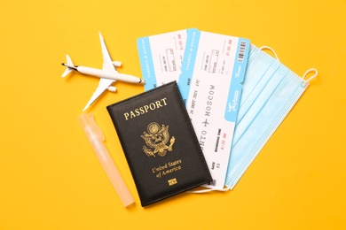 Photo of Flat lay composition with passport and protective mask on yellow background. Travel during quarantine