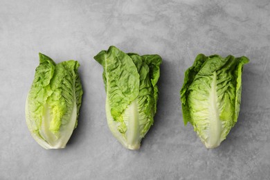 Photo of Fresh green romaine lettuces on light grey table, flat lay