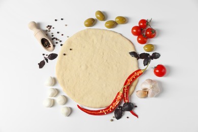 Fresh pizza dough and products on white background, flat lay