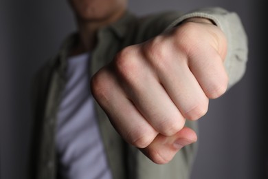 Photo of Man showing fist with space for tattoo on grey background, selective focus