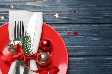 Photo of Christmas table setting on blue wooden background, top view. Space for text