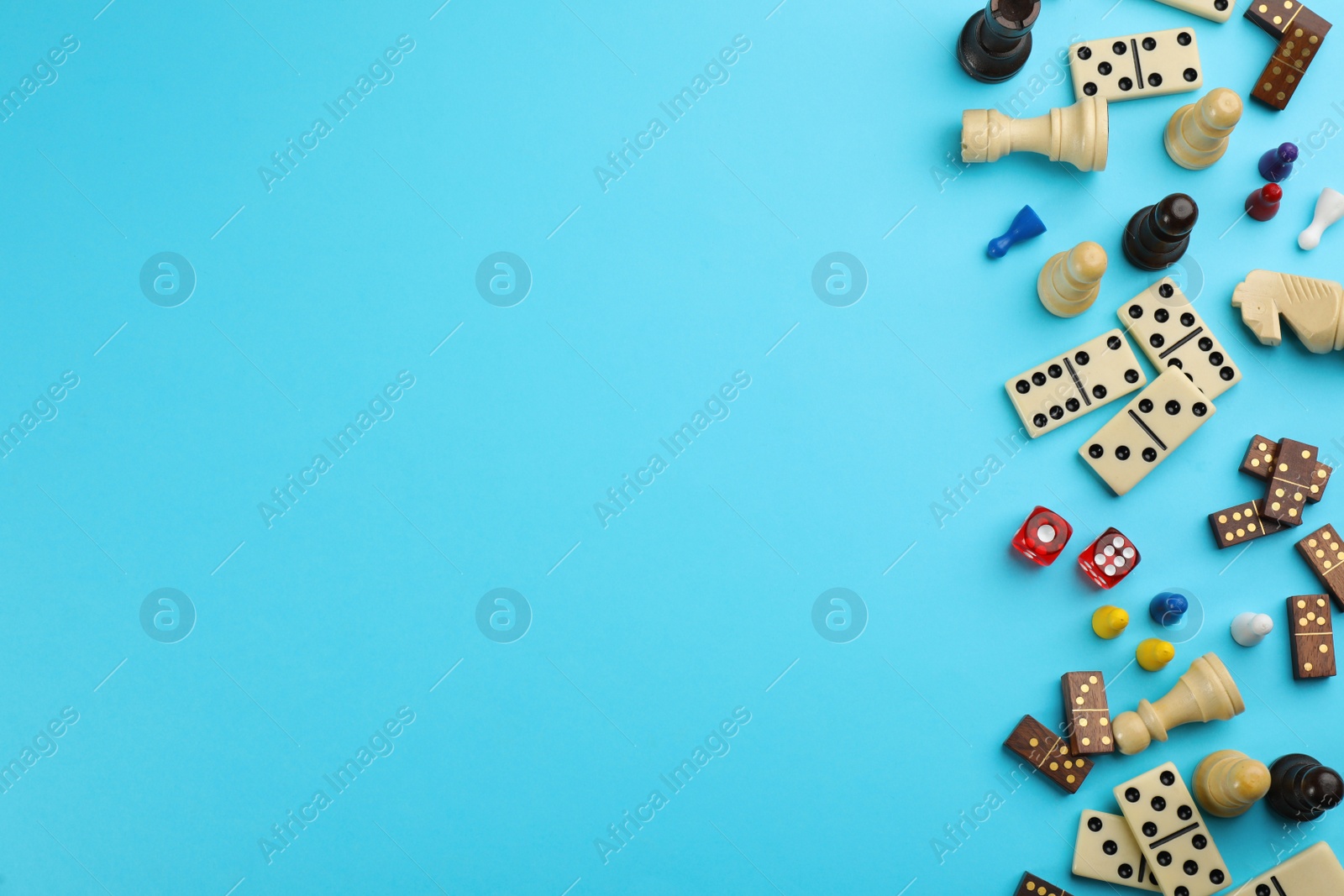 Photo of Components of board games on light blue background, flat lay. Space for text