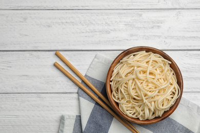 Tasty rice noodles on white wooden table, flat lay