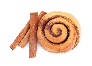 Photo of One tasty cinnamon roll and sticks isolated on white, top view