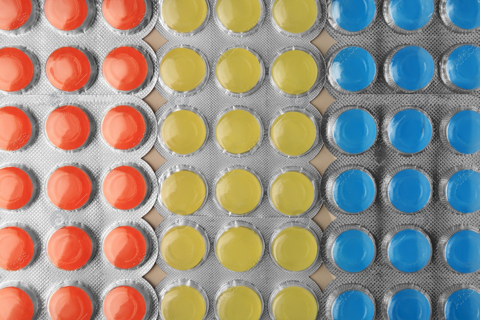 Photo of Blisters with colorful cough drops as background, top view