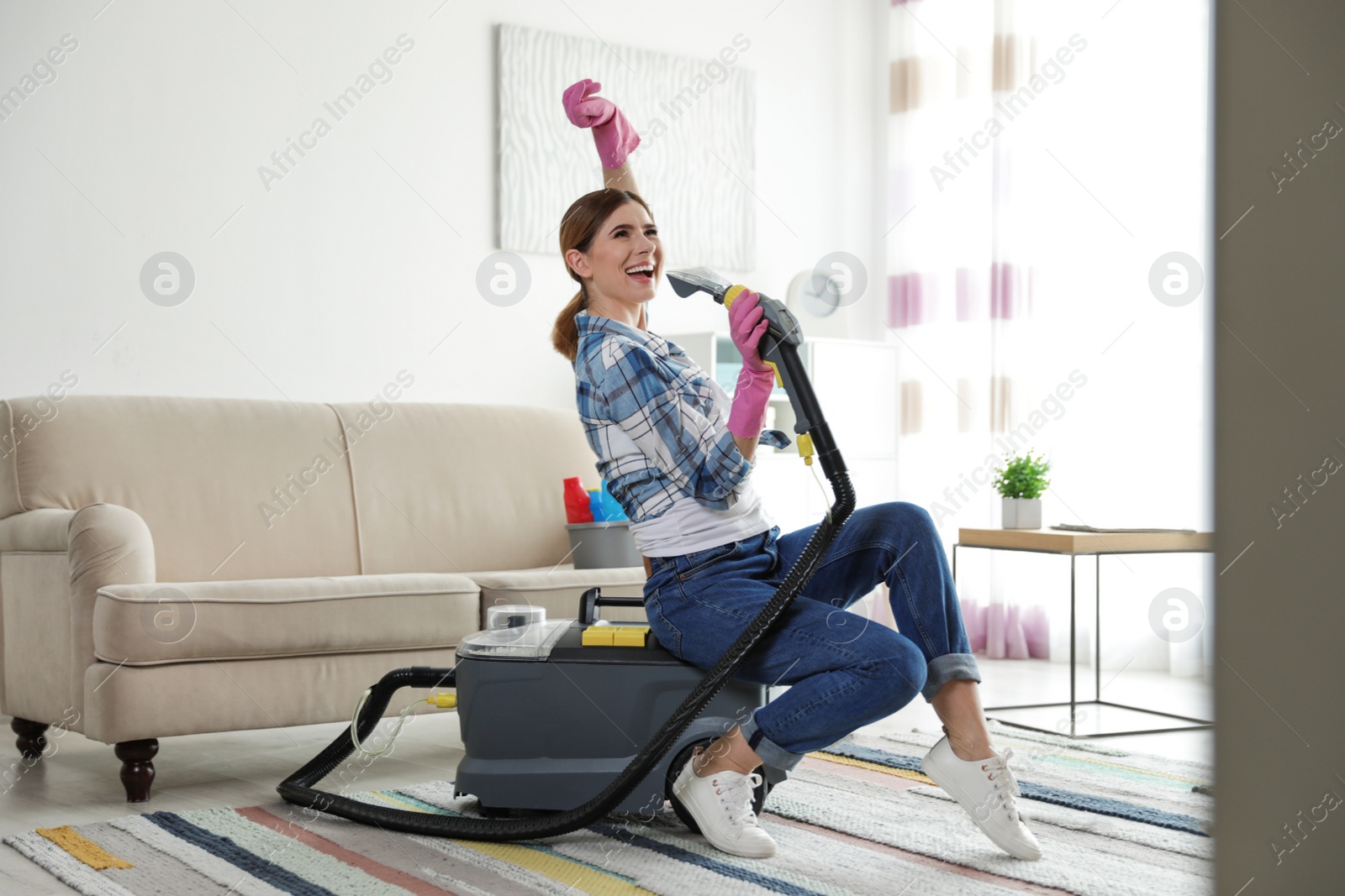 Photo of Happy woman having fun while cleaning room