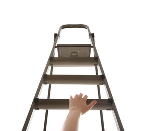 Photo of Woman climbing up stepladder against white background, closeup