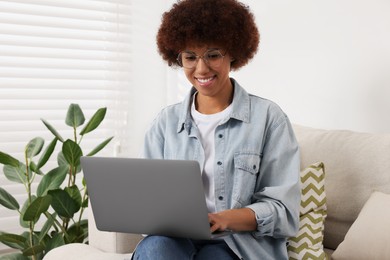 Photo of Beautiful young woman using laptop in room