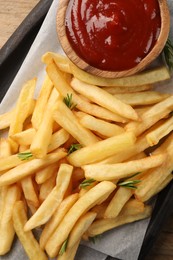 Delicious french fries served with ketchup on board, flat lay