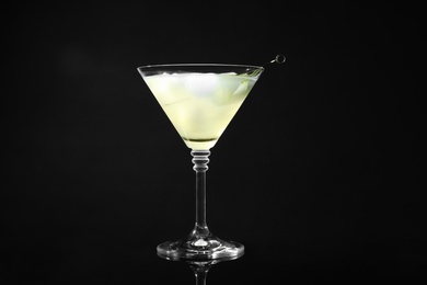 Photo of Glass of delicious cucumber martini on dark background