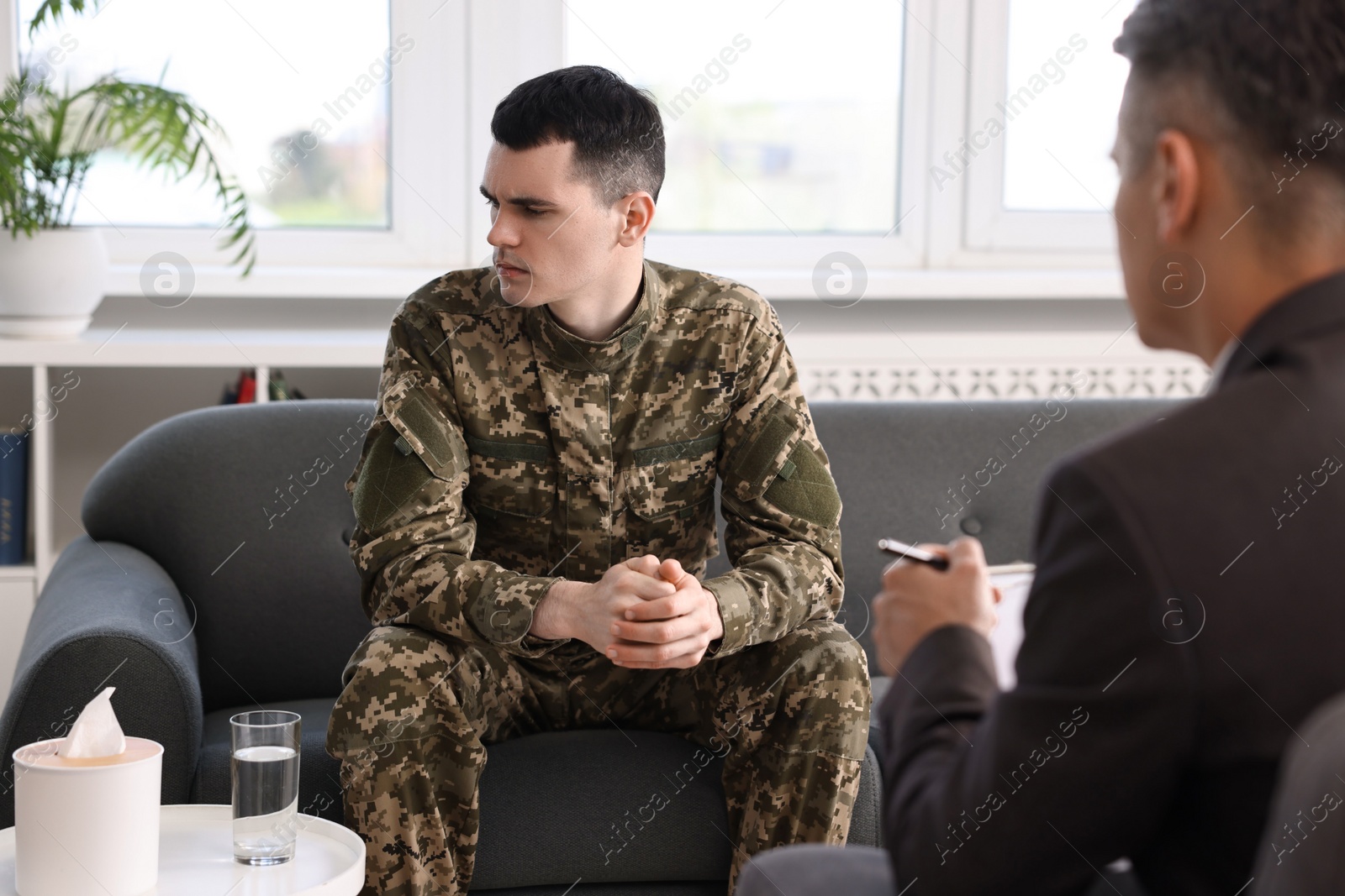 Photo of Professional psychotherapist working with military man in office