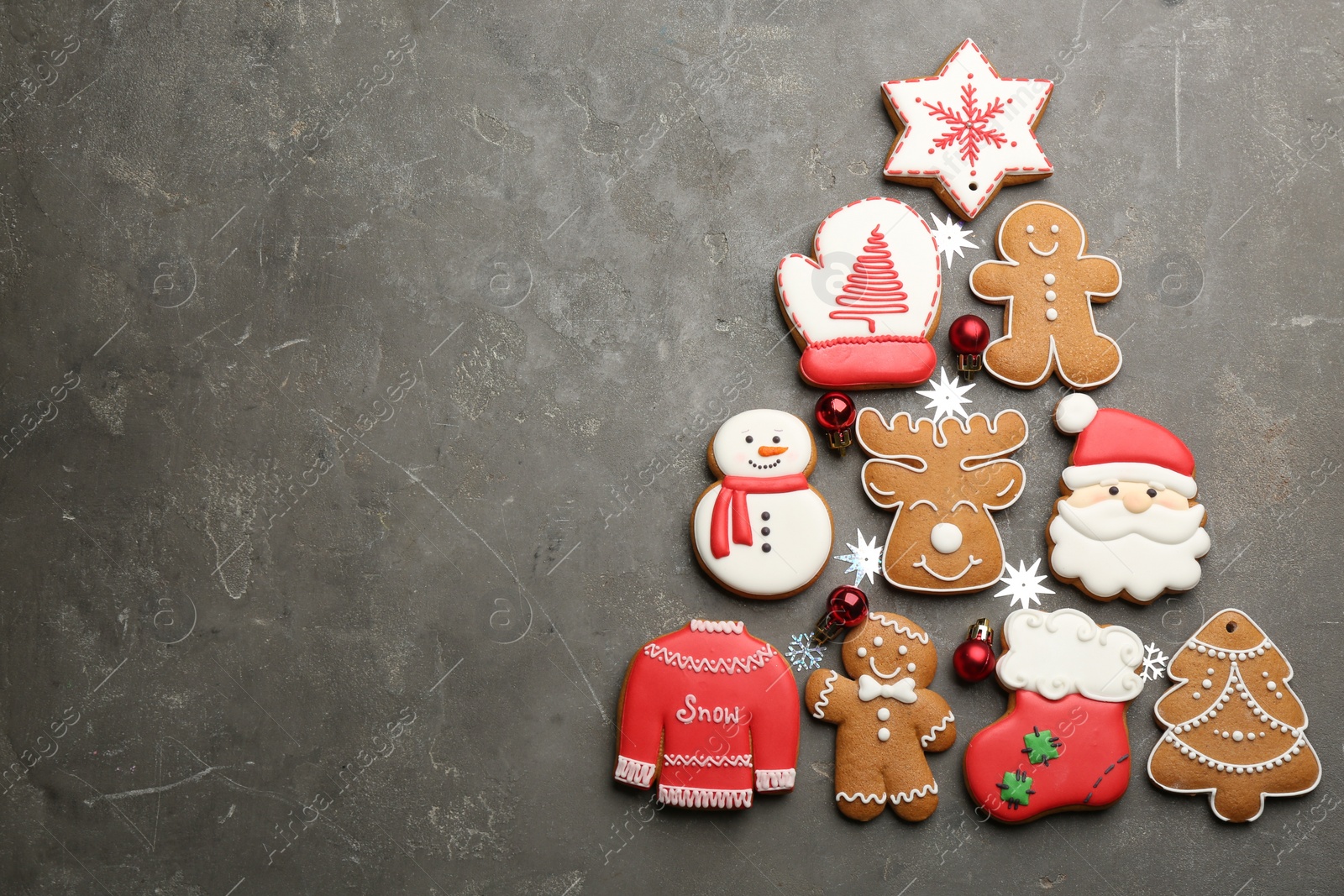 Photo of Christmas tree shape made of delicious gingerbread cookies on grey table, flat lay. Space for text