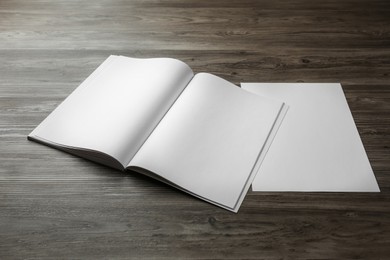 Sheet of paper and blank brochure on wooden table. Mockup for design