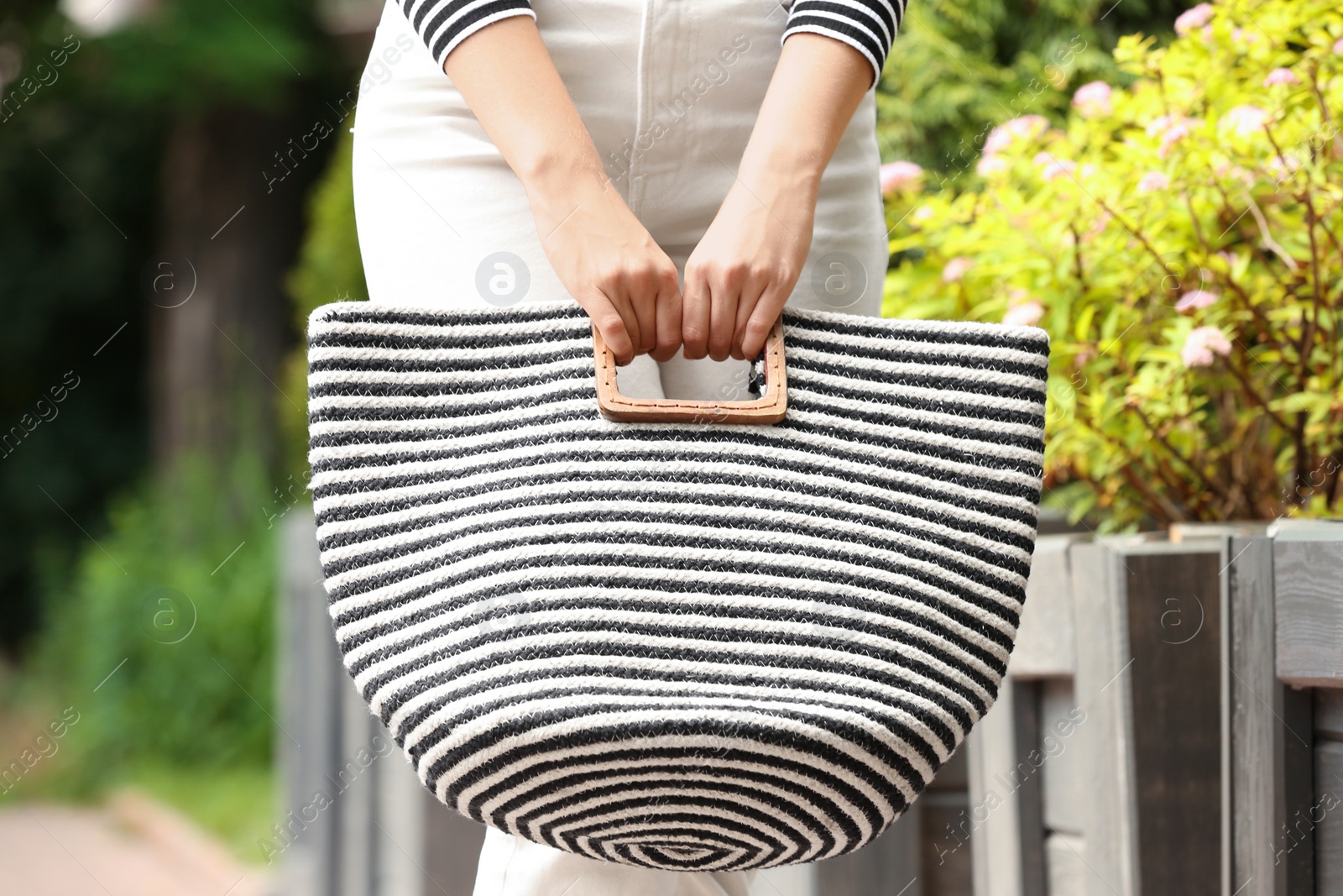 Photo of Young woman with stylish summer bag outdoors, closeup