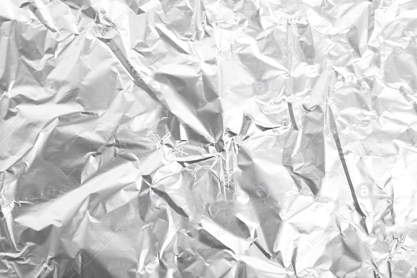 Photo of Crumpled silver foil as background, closeup view