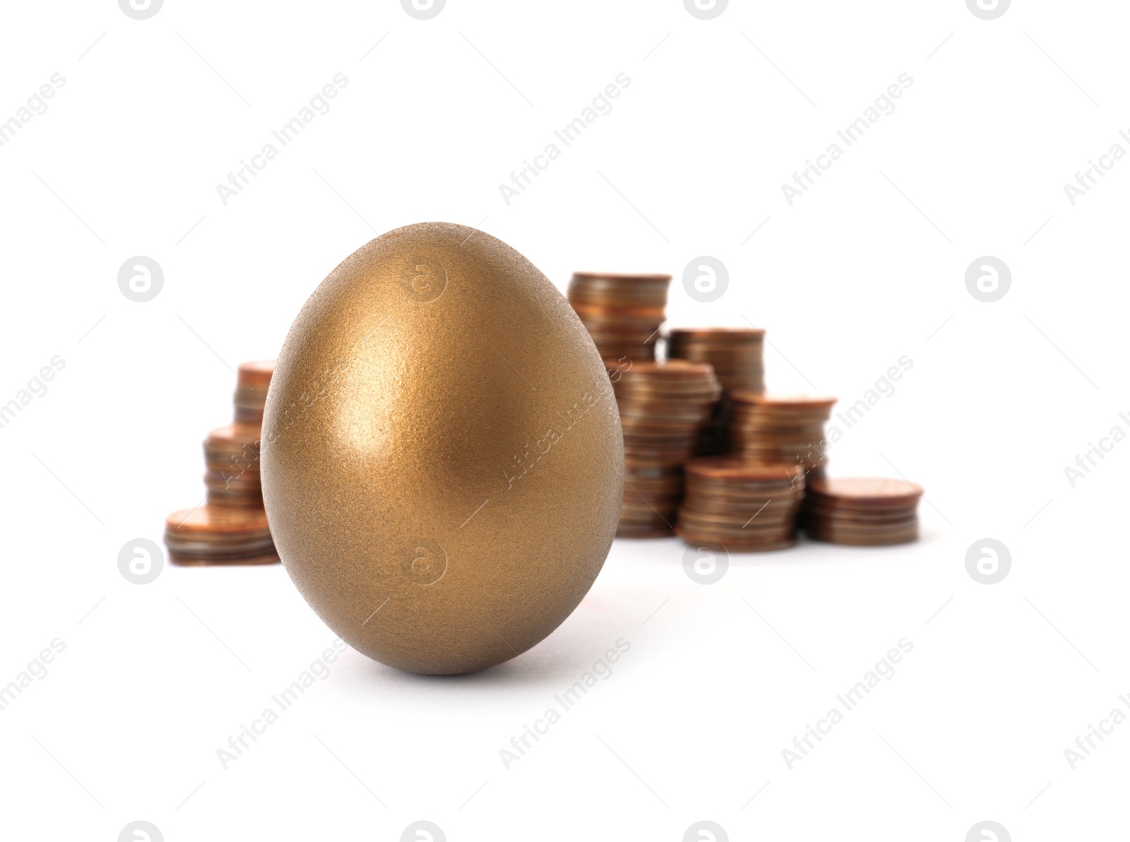 Photo of Gold egg and stacks of coins on white background