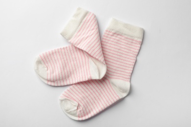 Photo of Cute child socks on white background, top view