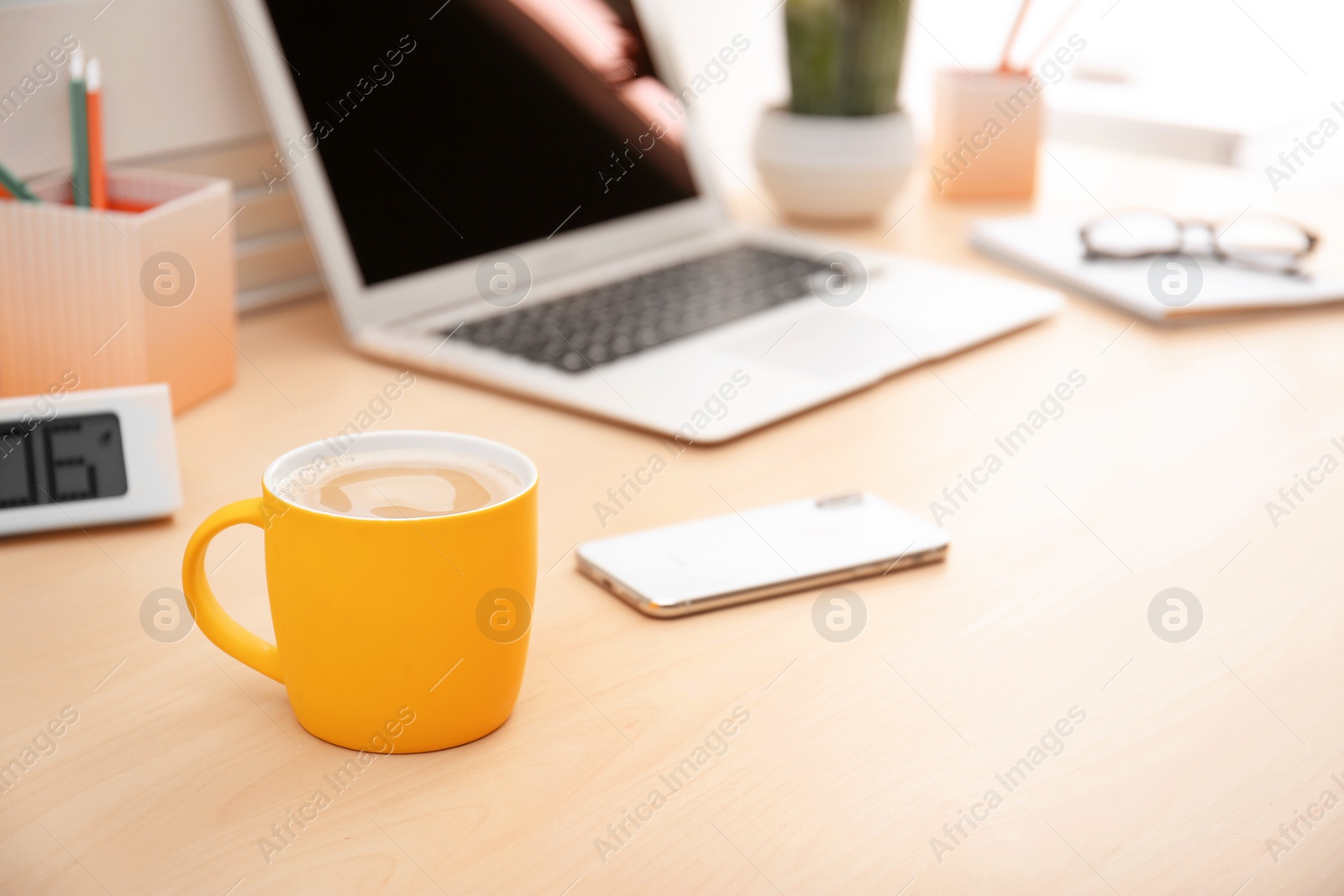 Photo of Yellow cup with coffee on office table. Space for text