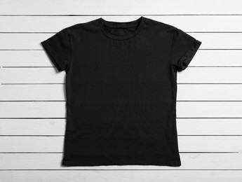 Stylish black t-shirt on white wooden background, top view