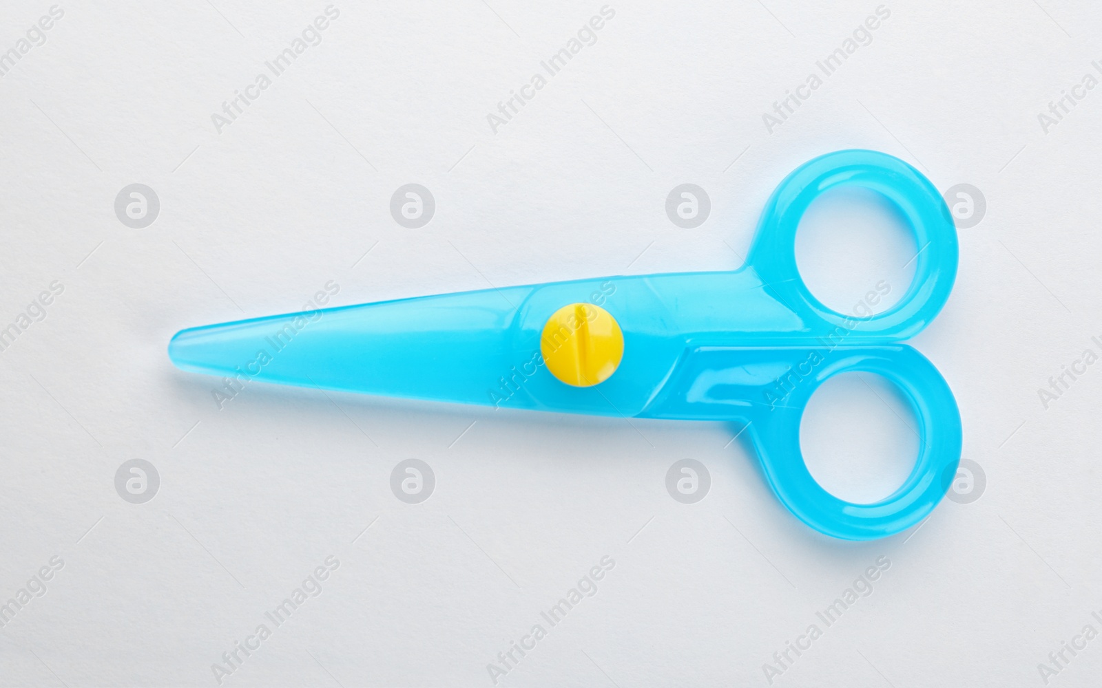 Photo of Colorful plastic scissors on white background. School stationery