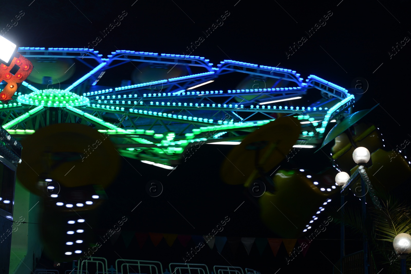 Photo of Illuminated attraction in amusement park at night