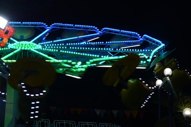 Photo of Illuminated attraction in amusement park at night
