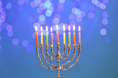 Photo of Hanukkah celebration. Menorah with burning candles against blurred lights