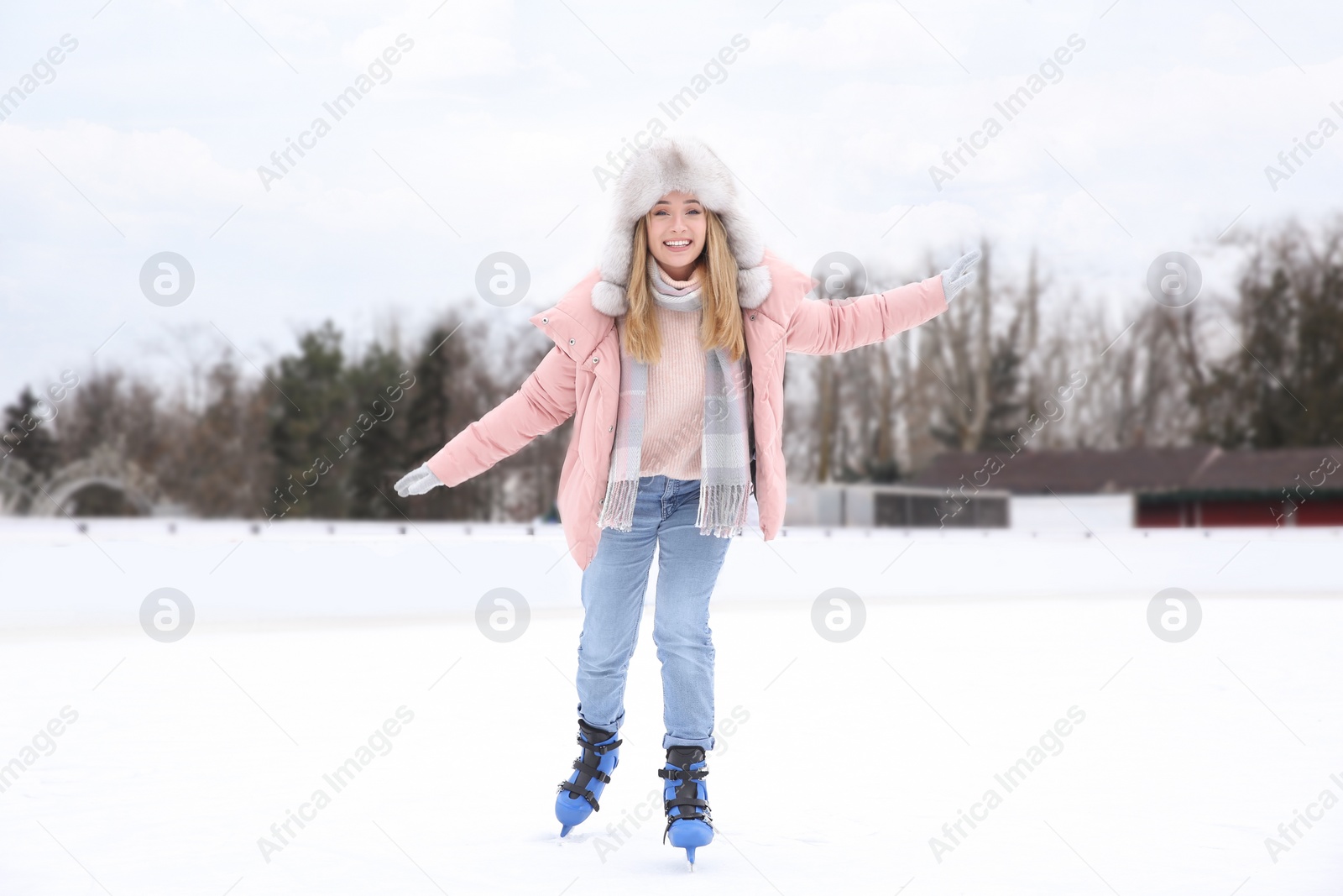 Image of Happy woman skating along ice rink outdoors