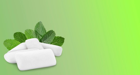 Menthol chewing gum pillows and mint leaves on green gradient background, space for text