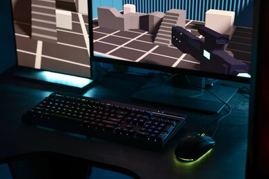 Playing video games. Computer monitor, keyboard and mouse on table indoors