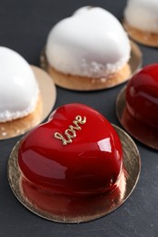 Photo of St. Valentine's Day. Delicious heart shaped cakes on black table, closeup