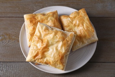 Delicious fresh puff pastries on wooden table, top view